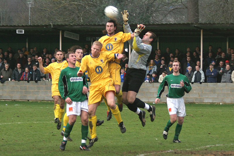 Tommy Dunn punches the ball away from Andy Martin and Steve Butler 
