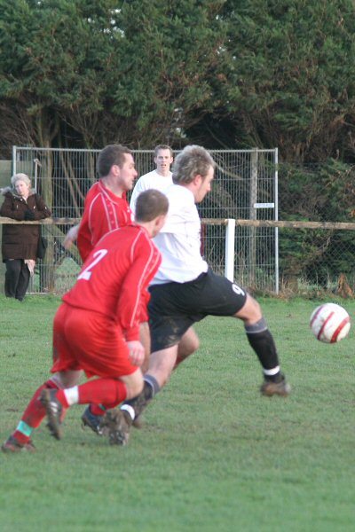 Josh Biggs gets the ball away from two defenders
