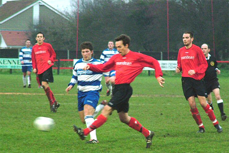 Neil Woolmer nicks the ball away from Ricky Mitchell with Chris Morrow close by
